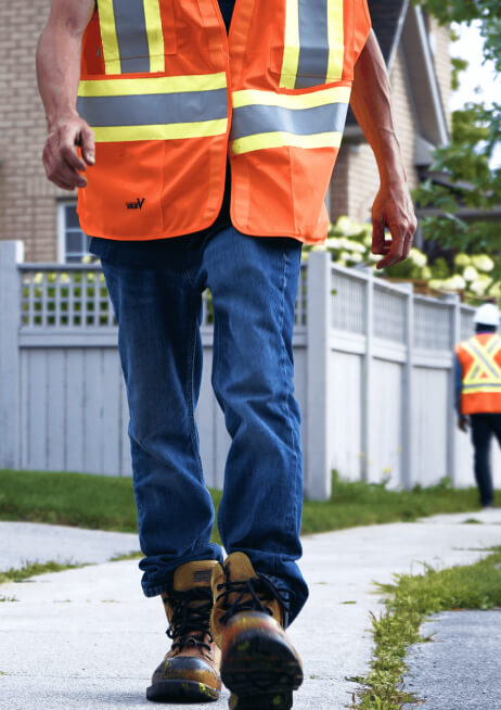 CUTI trainee walking a residential locate route in high-visibility gear